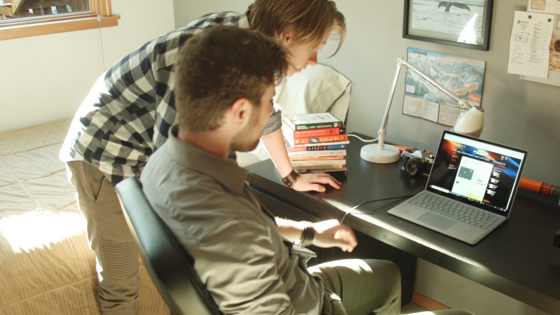 The two brothers bend over their laptop in the film, The Super Rocket